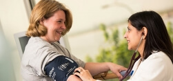 Dr. Disha Mookherjee takes the blood pressure of one of her patients